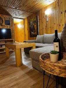 Sala de estar con sofá y mesa con botella de vino en “River Romance” Villa, en Kamchia
