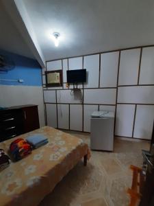 a bedroom with a bed and a tv in it at Pousada dos Ventos in Pôrto de Pedras
