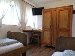 sypialnia z biurkiem, łóżkiem i drewnianą szafką w obiekcie Gästezimmer Emmis Erbe w mieście Peine