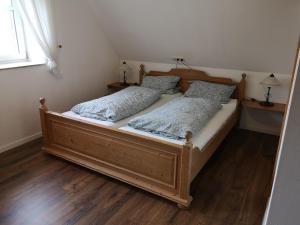 a bedroom with a wooden bed with two pillows at Gästezimmer Emmis Erbe in Peine