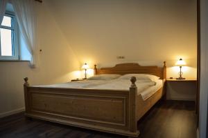 a bedroom with a large wooden bed with two lamps at Gästezimmer Emmis Erbe in Peine