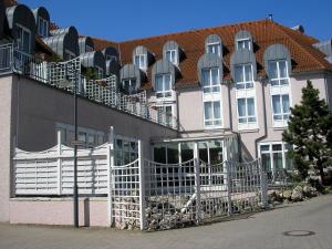 budynek z białymi ogrodzeniami i czerwonym dachem w obiekcie Parkhotel Altmühltal w mieście Gunzenhausen