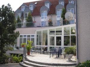 a building with a patio with tables and chairs at Parkhotel Altmühltal in Gunzenhausen