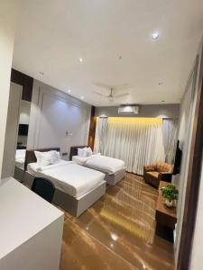 Habitación de hotel con 2 camas y sofá en VITS Jamnagar, en Jamnagar