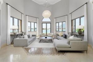 a living room with two couches and a table at Maison Privee - Palm Jumeirah Beach Front XL Villa with Private Pool in Dubai