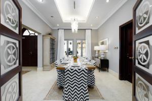 a dining room with a table and a chandelier at Maison Privee - Palm Jumeirah Beach Front XL Villa with Private Pool in Dubai