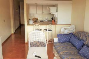 a living room with a couch and a kitchen at Garden city apartment privado in Playa Fañabe