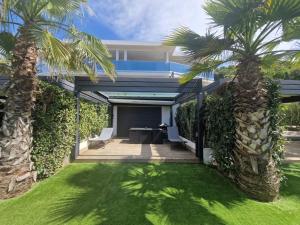 ein Haus mit Palmen und einer Terrasse in der Unterkunft Appartement avec vue magnifique in Grosseto-Prugna