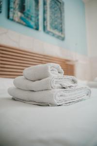 ターラントにあるB&B Dimora Mariùのバスルームのカウンターにタオルを積み上げます。