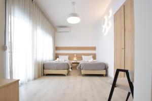 a bedroom with two beds and a table in it at John's Hotel in Chalkida