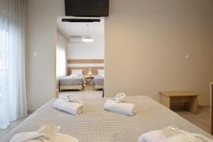 a bedroom with two beds with towels on them at John's Hotel in Chalkida