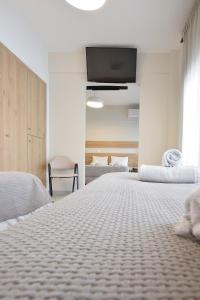 1 Schlafzimmer mit 2 Betten und einem Flachbild-TV in der Unterkunft John's Hotel in Chalkida