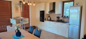 a kitchen with a table and a refrigerator at Blue Home in Balatonföldvár