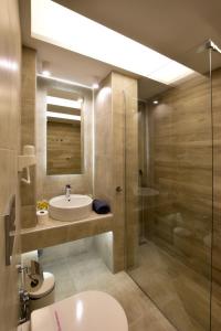 een badkamer met een wastafel, een toilet en een douche bij John's Hotel in Chalkida