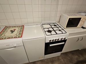 uma cozinha com um fogão e um micro-ondas em Maison Royan, 4 pièces, 6 personnes - FR-1-71-52 em Royan