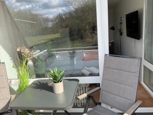 eine Terrasse mit einem Tisch, Stühlen und einem Fenster in der Unterkunft Ferienwohnung 1 Zimmer App Ankerplatz 43 im Olympiazentrum in Kiel