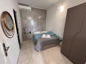 a small bedroom with a bed and a mirror at Birds Villa Apartments - Including Car Rental in Perissa