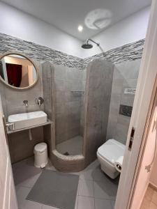 y baño con ducha, aseo y lavamanos. en Birds Villa Apartments - Including Car Rental, en Perissa
