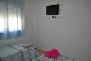 - une chambre avec un lit et des serviettes rouges dans l'établissement Triplex a 200 metros de la playa, à Gandía