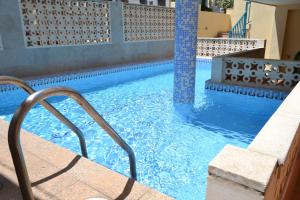 - une piscine d'eau bleue dans un bâtiment dans l'établissement Triplex a 200 metros de la playa, à Gandía