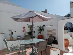 stół i krzesła z parasolem na patio w obiekcie The Corner Terraza w mieście Alcaudete