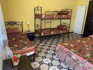 a room with two bunk beds and a table at Park-hotel Abkhazia in Tsandrypsh