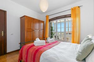 una camera da letto con un letto con due asciugamani sopra di Sweet Home Sagres a Sagres