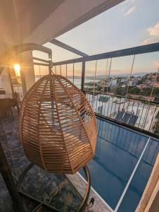 un cesto appeso in rattan accanto alla piscina di Sea Breeze Apartment a Milas