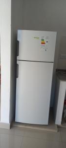 a white refrigerator sitting in a kitchen next to a wall at Pampa Modern Apartment in Simoca