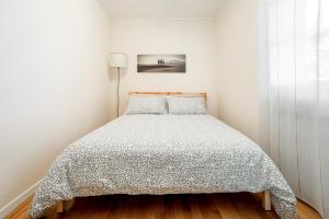 Dormitorio blanco con cama con edredón en Il Nido en Pienza