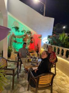a group of people sitting at a table in a restaurant at بيت العُمري (ام قيس) in Um Qeis