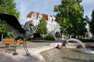 una estatua de un pájaro de pie en una fuente en Parkhotel Altmühltal, en Gunzenhausen