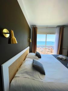 a bedroom with a bed with a view of the ocean at Hotel La Potiniere in Hyères