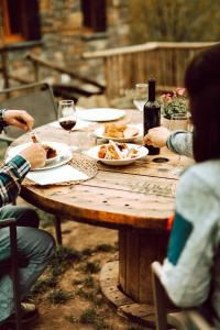 un grupo de personas sentadas alrededor de una mesa de madera con comida y vino en Hotel de Montaña Lamiana, en Lamiana 37 fotos más