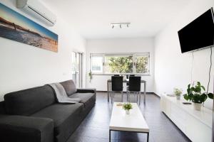 een woonkamer met een bank en een tv bij Apartamento Oceano in Albufeira