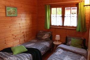 um chalé de madeira com 2 camas e uma janela em Oaza Dąbek em Dąbki