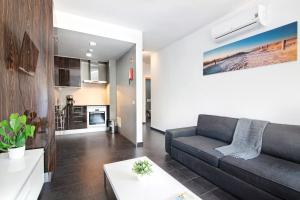 een woonkamer met een bank en een keuken bij Apartamento Oceano in Albufeira