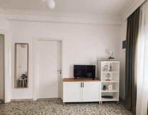 ein Wohnzimmer mit einem TV auf einem weißen Schrank in der Unterkunft RODIES apartment in Chalkida