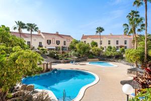 una imagen de una piscina en un complejo con palmeras en Lovely Holiday in Golf del Sur en San Miguel de Abona