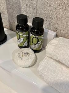 2 bottiglie di sapone e asciugamani su un lavandino del bagno di Antibes New Luxe Duplex Studio a Antibes