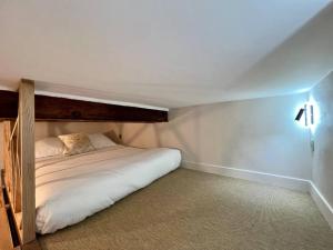 un letto in una piccola camera con lenzuola bianche di Antibes New Luxe Duplex Studio a Antibes