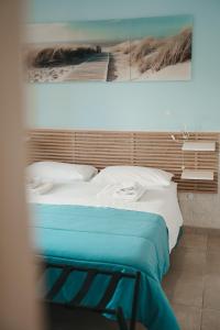 a bedroom with a bed with a painting on the wall at B&B Dimora Mariù in Taranto