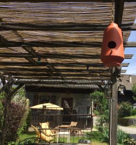 eine hölzerne Pergola mit einem Tisch und Stühlen darunter in der Unterkunft Au Refuge de Blanche in Verchères