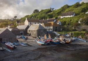 a group of boats sitting on the sand in a village at Renes Cottage in Ruan Minor