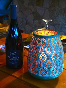 a bottle of wine sitting next to a pot at A ChiOsella in Corbara