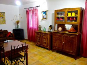 a living room with a wooden cabinet and a table at A ChiOsella in Corbara