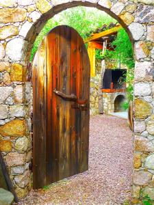 a large wooden door in a stone wall at A ChiOsella in Corbara