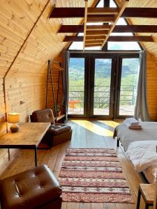 a bedroom with a bed and a table in a room at Kazbegi Kuro Cottages in Stepantsminda