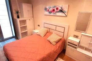 - une chambre avec un lit orange et une peinture murale dans l'établissement Apartamento Playa Foz, à Foz