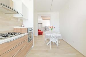 a kitchen with a table and a table and chairs at Appartamento Vitalba by BarbarHouse in Ginosa Marina